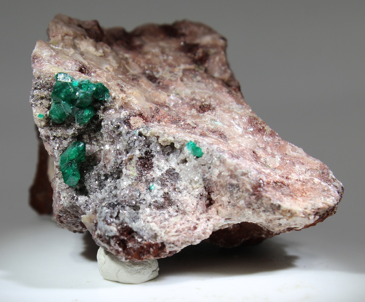 Dioptas-Kristalle auf rötlicher Quarzmatrix aus der Ntola Mine bei Mindouli, Pool Region, Republik Kongo.