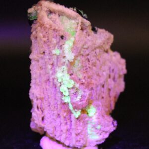 Gelbgrün fluoreszierender Glasopal auf Feldspat unter langwelligem UV-Licht