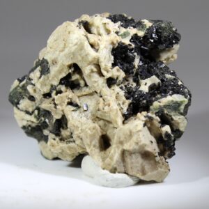 Hochglanzende, schwarze Kristalle von Babingtonit auf Matrix.