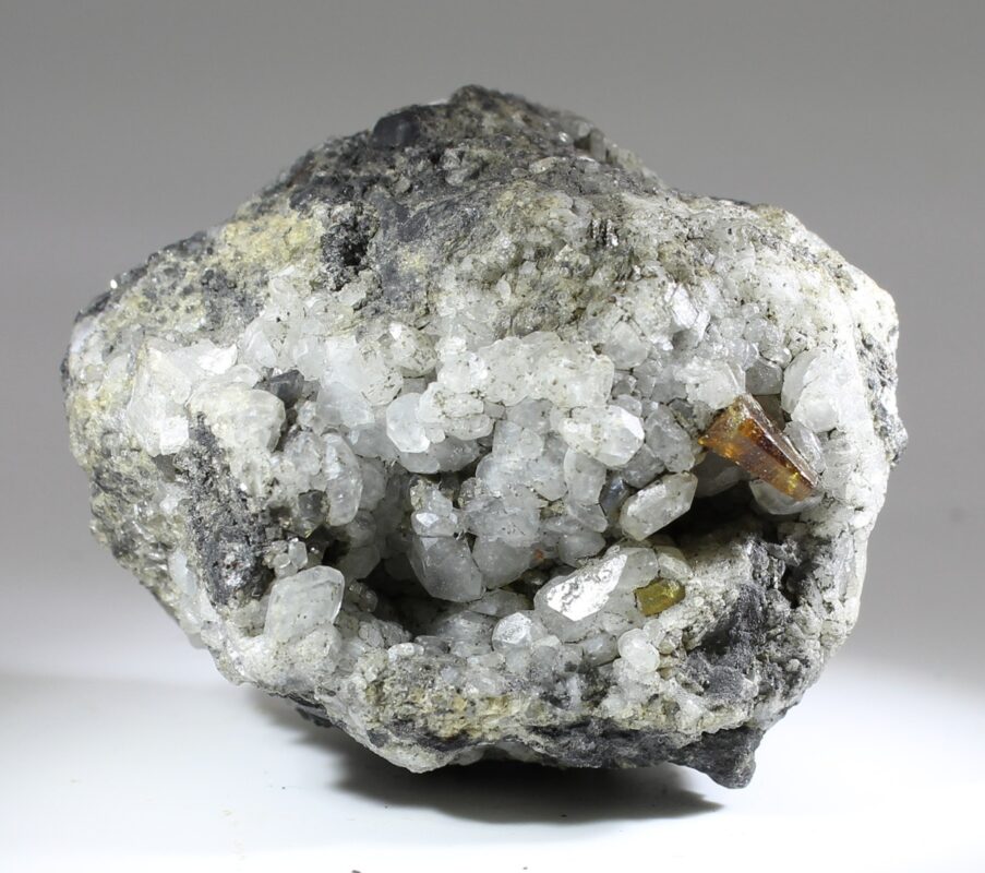 Parisite-(Ce) on light-colored calcite matrix from the Muzo District, with a brown to golden-yellow crystal freely exposed on the hydrothermal vein mineralization