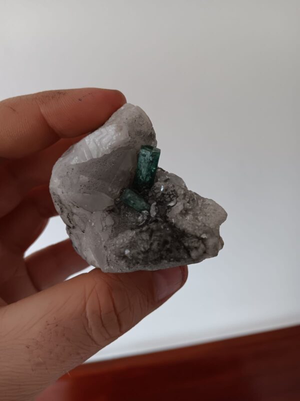 Smaragdstufe aus der Mina Coscuez mit zwei grünen Kristallen auf heller Calcitmatrix.